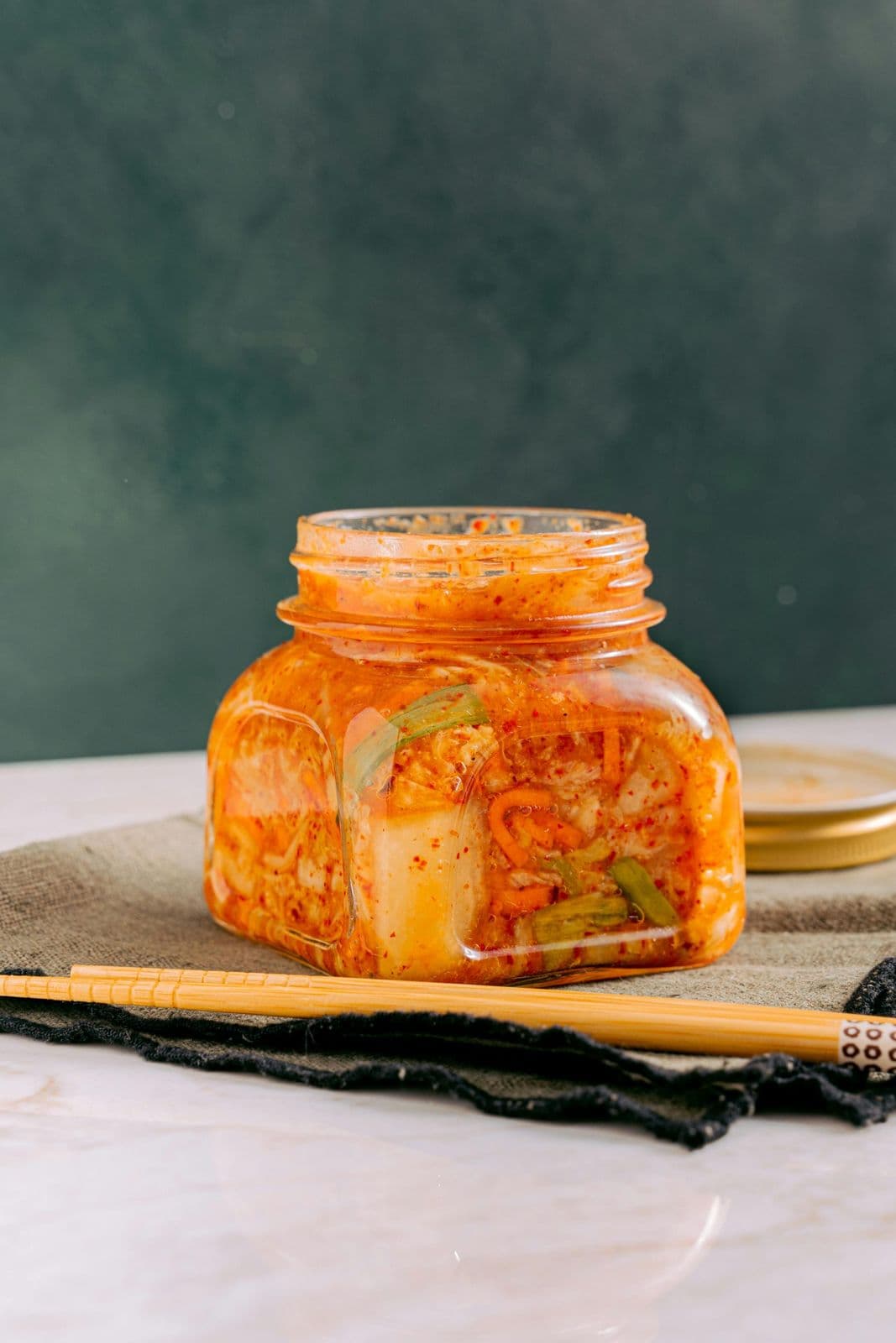 Fermented vegetables including kimchi in glass jar for digestion support.